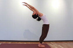 2.息を吸いながら両腕を肘を曲げずに上に伸ばし、膝を曲げずに骨盤を前に押し出すように腰から後ろへ反って首の力を抜く。