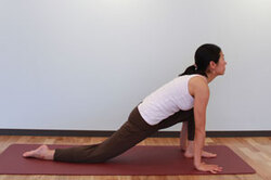 4.息を吸いながら右脚（※左）を大きく一歩後ろへ下げて右膝、右脚の甲を床におろし、背中を反らせて上を見上げる。