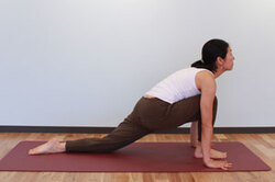 9.息を吸いながら、右脚（※左）を前に出して両手の間に置き、反対の脚の膝、脚の甲を床におろし、4と同様に背中を反らせて上を見上げる。