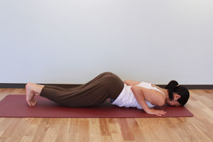 6.息を吐きながら、膝、胸、額と順に床へ降ろす。腰は床から浮かせ、爪先を下に丸める。